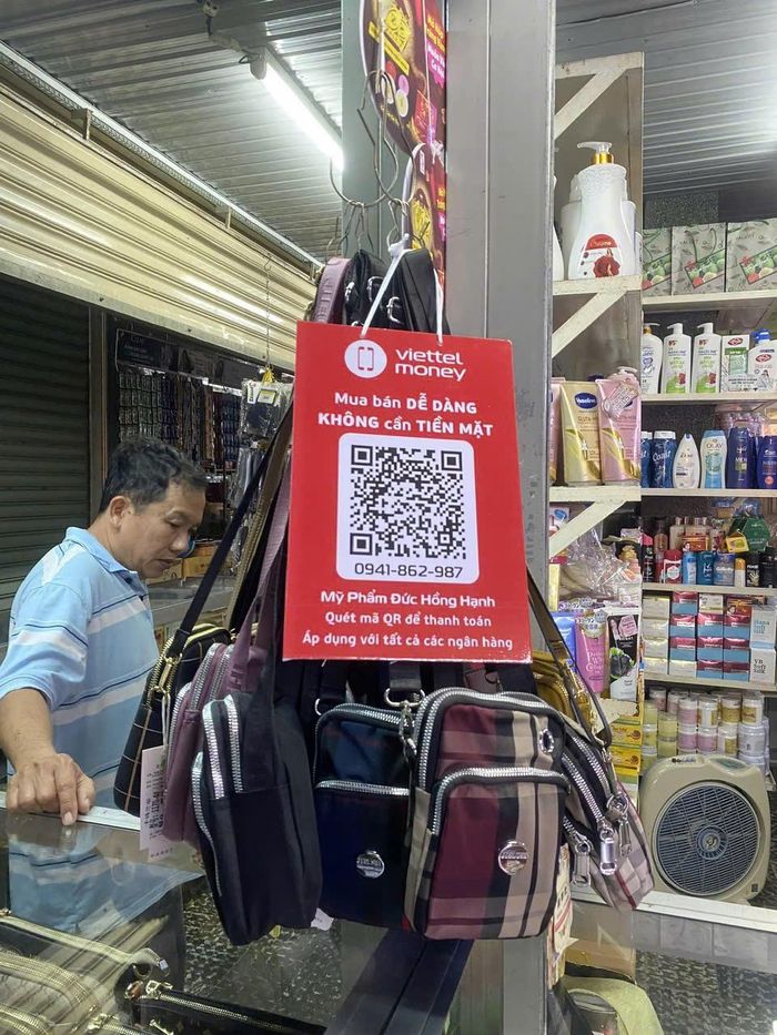 Tiểu thương tại chợ triển khai thanh toán bằng mã QR, góp phần lan tỏa thói quen giao dịch không dùng tiền mặt trong cộng đồng. (Ảnh: Thanh Lâm).