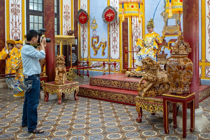  Nhóm du khách trẻ hóa thân thành vua, hoàng hậu chụp ảnh trong Đại nội Huế. Để phục vụ nhu cầu lưu niệm trong trang phục cung đình, tại nhà Hữu Vu (Đại nội) và Minh Khiêm Đường (Lăng Tự Đức) mở dịch vụ chụp ảnh cùng các diễn viên, nghệ sĩ trong trang phục cung đình, mức giá dao động 50.000-195.000 đồng/người/lượt. 