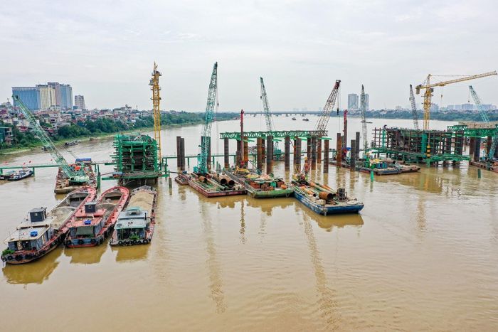 Nhiều sà lan, cần cẩu và thiết bị chuyên dụng được huy động phục vụ thi công các trụ cầu chính. Ảnh: Trung Nguyên - TTXVN