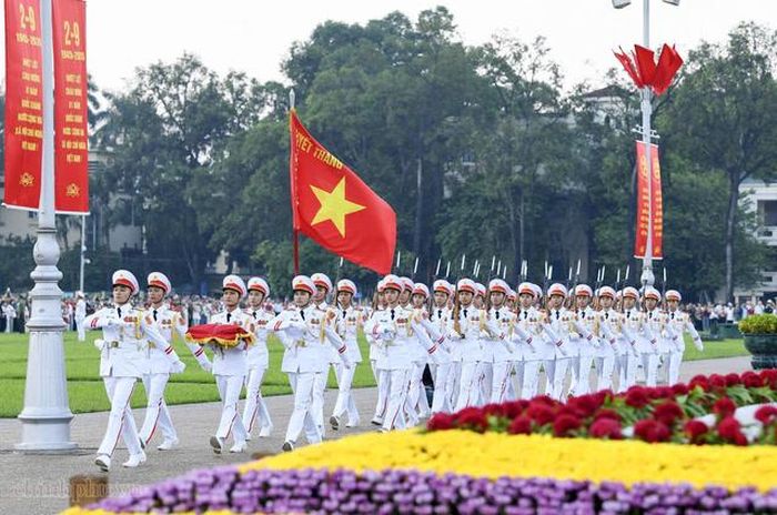 Các chiến sĩ thực hiện nhiệm vụ với lá cờ đỏ sao vàng dẫn đầu đội hình. Ảnh: chinhphu.vn