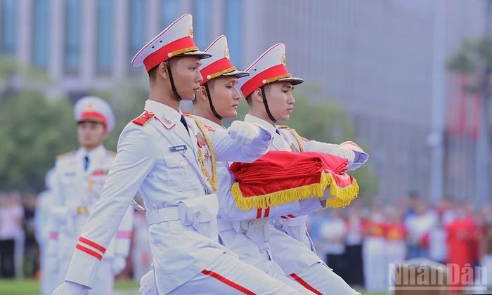 3 chiến sĩ mang Quốc kỳ tiến về phía cột cờ. (Ảnh: TÙNG MAI)