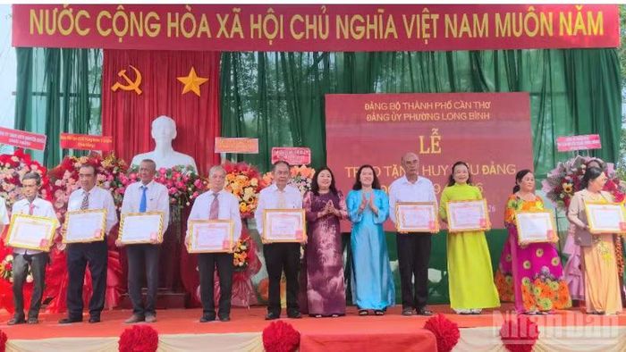 Lãnh đạo thành phố Cần Thơ trao tặng 34 Huy hiệu Đảng cho 32 đảng viên phường Long Bình. (Ảnh: VĂN ÚT)