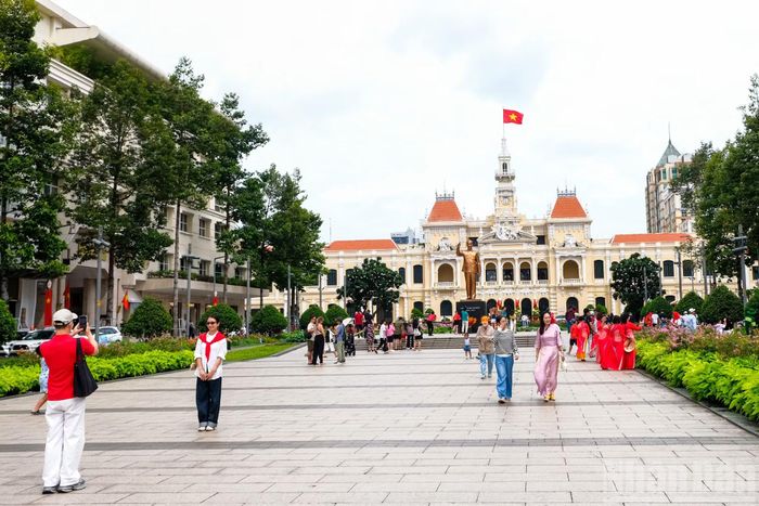 Người dân, du khách tham quan, chụp ảnh lưu niệm tại khu vực tượng đài Chủ tịch Hồ Chí Minh.
