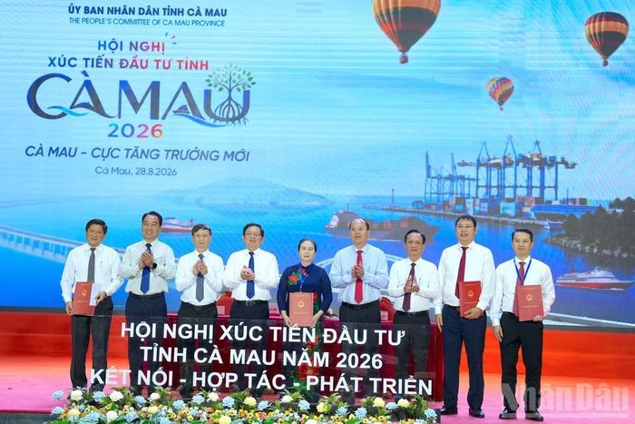 Lãnh đạo tỉnh Cà Mau trao biên bản ghi nhớ cho các nhà đầu tư trước sự chứng kiến của Phó Thủ tướng Chính phủ Hồ Quốc Dũng (thứ 4 từ trái qua) và Bí thư Tỉnh ủy Cà Mau Nguyễn Hồ Hải (thứ 4 từ phải qua). (Ảnh: HỮU TÙNG)