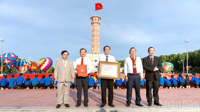 Đại diện lãnh đạo tỉnh Cà Mau đón nhận Bằng Kỷ lục “Lá cờ Tổ quốc bằng vải lớn nhất Việt Nam” do đại diện Trung ương Hội Kỷ lục gia Việt Nam trao tặng. (Ảnh: HỮU TÙNG)
