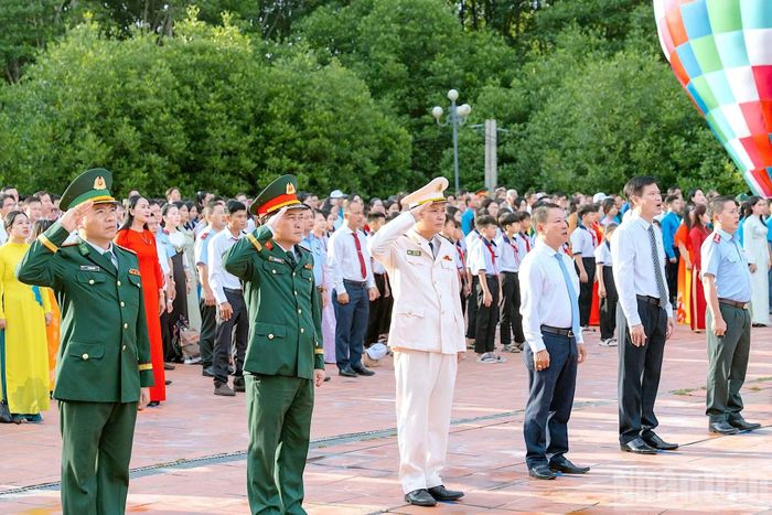 Cán bộ, chiến sĩ lực lượng vũ trang và đại biểu hướng ánh mắt thành kính về phía Cột cờ Hà Nội và cùng hát Quốc ca trong thời khắc thiêng liêng. (Ảnh: HỮU TÙNG)