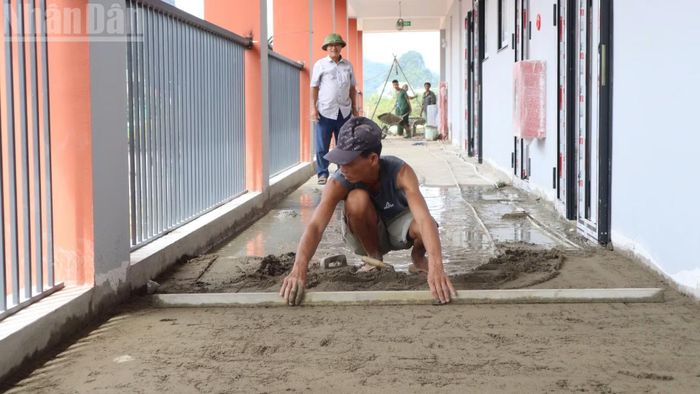 Sàn dãy nhà trung học cơ sở ở tầng 3 đang được gấp rút ốp lát gạch.