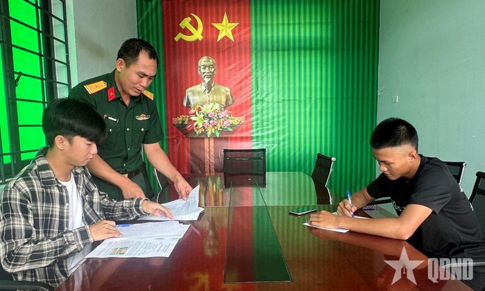 Cán bộ Ban CHQS xã Ia Rvê hướng dẫn thanh niên làm thủ tục đăng ký tình nguyện nhập ngũ.