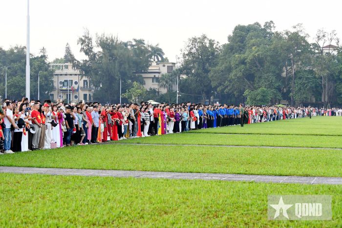Người dân và du khách gác lại các hoạt động, hướng mắt dõi theo lá Quốc kỳ từ từ được kéo lên đỉnh cột cờ, cùng hát vang "Tiến quân ca".