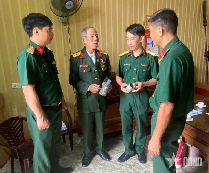 Cựu chiến binh Nguyễn Chính Quy (thứ hai, từ trái sang) kể về những kỷ vật cùng ông chiến đấu ở chiến trường Quảng Trị.