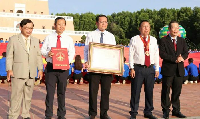  Đại diện Tổ chức Kỷ lục Việt Nam trao Bằng Kỷ lục “Lá cờ Tổ quốc bằng vải lớn nhất Việt Nam” cho Phó Chủ tịch UBND tỉnh Cà Mau Ngô Vũ Thăng (giữa) 