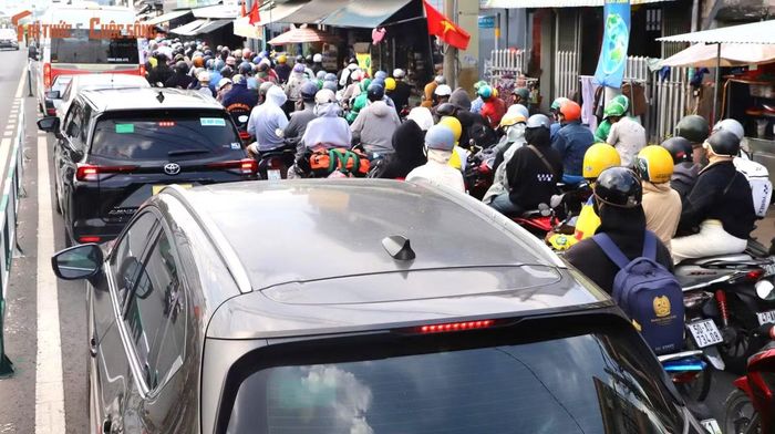 Trên các xe máy, người lớn chở theo con nhỏ, phía trước, phía sau chất đầy balô, túi xách, thùng quà quê; có xe còn buộc thêm cả bao tải, thùng xốp lỉnh kỉnh, khiến việc di chuyển càng thêm vất vả giữa dòng xe đông đúc.