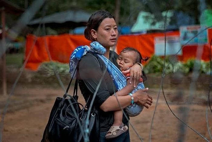 Một người phụ nữ bế em bé chờ tin người thân mất tích tại một doanh trại quân đội ở Trishuli, Nepal, ngày 28/8. (Nguồn: Getty Images)