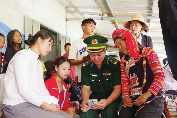 Cán bộ đồn Biên phòng Ka Lăng hướng dẫn đồng bào dân tộc La Hủ cách sử dụng các phần mềm, ứng dụng thông minh trên điện thoại