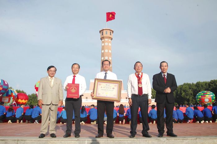 Ông Dương Duy Lâm Viên – Phó Chủ tịch kiêm Tổng Thư ký Trung ương Hội Kỷ lục gia Việt Nam (bìa phải) và ông Hà Phước Dũng (bìa trái) trao Bằng Kỷ lục “Lá cờ Tổ quốc bằng vải lớn nhất Việt Nam” cho ông Ngô Vũ Thăng – Phó Chủ tịch UBND tỉnh (giữa); trao Quyết định xác lập Kỷ lục cho ông Nguyễn Quốc Thanh – Giám đốc Sở VH,TT&DL (thứ 2 từ trái sang) và trao Huy hiệu Kỷ lục cho ông Lê Văn Dũng – Giám đốc Vườn Quốc gia Mũi Cà Mau (Ảnh: T.N).