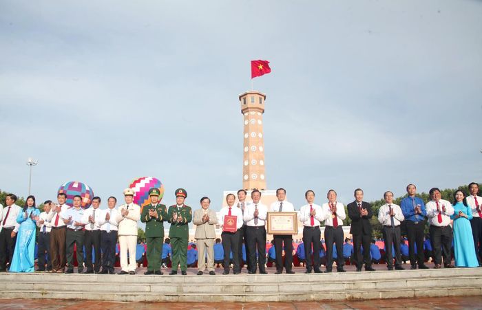 Lãnh đạo tỉnh Cà Mau và các đại biểu phấn khởi chụp ảnh lưu niệm trong khoảnh khắc đón nhận Kỷ lục “Lá cờ Tổ quốc bằng vải lớn nhất Việt Nam” trao tặng cho tỉnh (Ảnh: T.N).