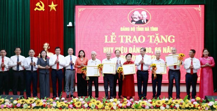 Phó Thủ tướng Thường trực Chính phủ Phạm Gia Túc cùng lãnh đạo tỉnh Hà Tĩnh tặng hoa chúc mừng các đảng viên nhận Huy hiệu 80 năm, 65 năm tuổi Đảng. Ảnh: TT xã Đức Quang