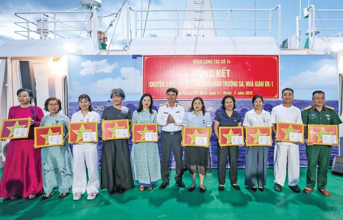 Tặng cờ Tổ quốc và kỷ niệm chương cho các đại biểu sau chuyến đi. Ảnh: Nguyễn Thành