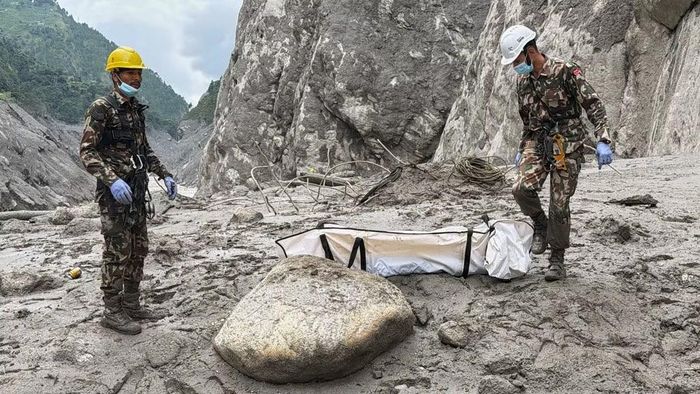 Binh lính Nepal khiêng thi thể công nhân được tìm thấy tại hiện trường dự án thủy điện ở Upper Trishuli ngày 1/9. (Ảnh: AP)