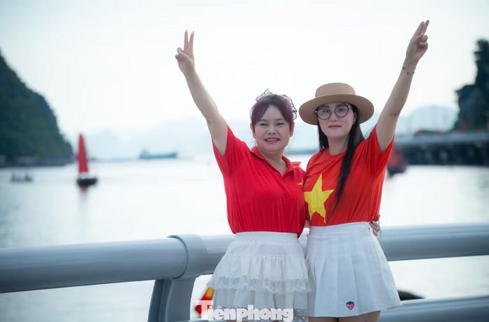 Người dân chụp ảnh cùng cánh buồm ba vách đỏ thắm trên vịnh Hạ Long, đối diện Công viên hoa Hạ Long trong những ngày Quảng Ninh lên thành phố trực thuộc Trung ương.
