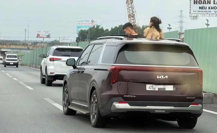 Hình ảnh hai đứa trẻ thò đầu khỏi ô tô đang chạy trên cao tốc.