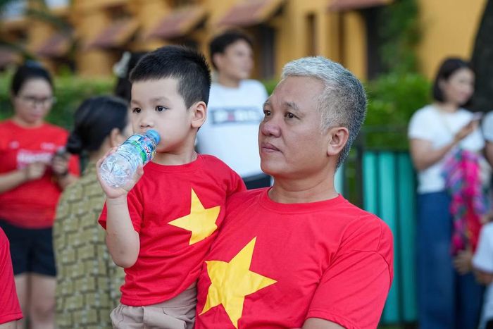 Trong dòng người có nhiều gia đình đưa con nhỏ về Hà Nội. Những em bé khoác trên mình trang phục mang màu cờ đỏ sao vàng, theo bố mẹ xếp hàng trong không khí trang nghiêm của ngày Quốc khánh.