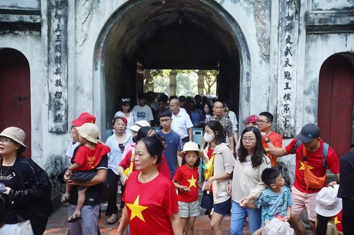 Nhiều người mặc áo cờ đỏ sao vàng khi tham quan Văn Miếu - Quốc Tử Giám. Đây cũng là trang phục được nhiều người dân Việt Nam lựa chọn khi tham quan một số danh lam, di tích trong dịp Quốc khánh 2/9.