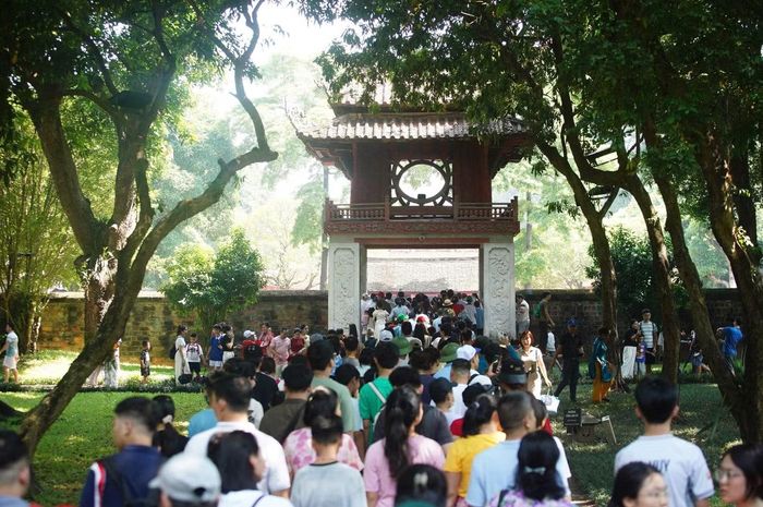 Nhiều gia đình đưa theo trẻ nhỏ. Các em hào hứng khám phá không gian Văn Miếu - Quốc Tử Giám, tìm hiểu những câu chuyện về trường đại học đầu tiên của Việt Nam và chụp ảnh lưu niệm.