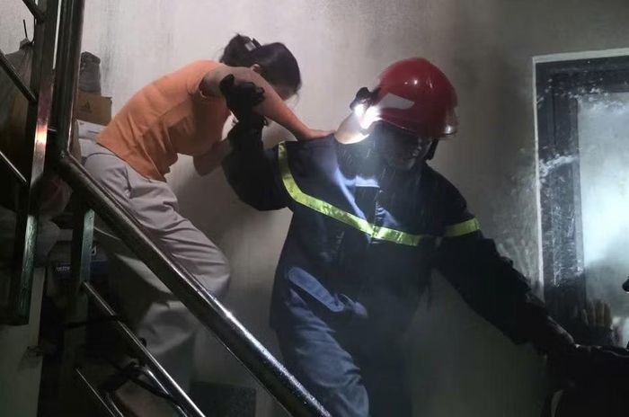 Lực lượng chữa cháy kịp thời đưa các nạn nhân ra khỏi ngôi nhà bị cháy.