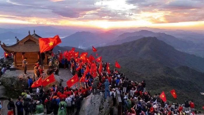 Các bạn trẻ leo núi, mang theo cờ tổ quốc để tham gia lễ chào cờ đặc biệt ý nghĩa.