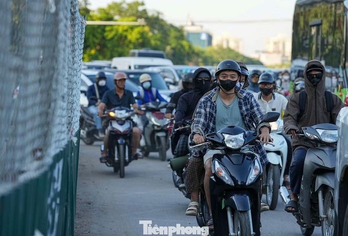 Dòng xe máy nối đuôi di chuyển qua phần đường hẹp tại nút giao Cổ Linh - cầu Vĩnh Tuy. Lượng phương tiện tăng cao trong chiều cuối kỳ nghỉ lễ khiến khu vực này nhiều thời điểm ùn ứ.
