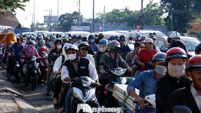 Ghi nhận từ khoảng 16h30, trên trục đường Lê Khả Phiêu (quốc lộ 1), lượng phương tiện từ các tỉnh miền Tây hướng về trung tâm TPHCM tăng nhanh. Dòng xe máy, ô tô nối dài, di chuyển chậm qua nút giao giữa đường Lê Khả Phiêu - Bùi Thanh Khiết - Đoàn Nguyễn Tuấn.