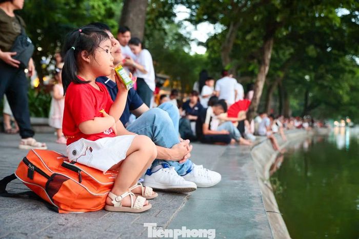 Các em nhỏ được người thân đưa đến Hồ Gươm từ sớm, háo hức chờ xem pháo hoa mừng Quốc khánh.