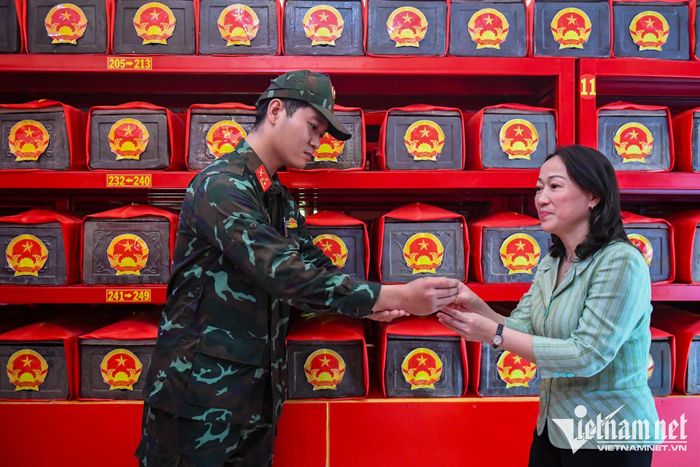 Chiến sĩ Phạm Phú Lữ hướng dẫn người dân vào thắp hương tại nhà quàn liệt sĩ.