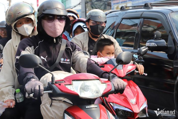 Dưới nắng nóng hầm hập và khói bụi, nhiều em nhỏ mệt mỏi, ngủ gật hay khóc quấy trên xe khi cùng cha mẹ trở lại TPHCM.