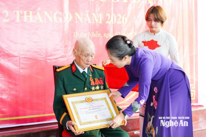 Phó Bí thư Tỉnh ủy Võ Thị Minh Sinh trao quyết định, giấy chứng nhận Huy hiệu 80 năm tuổi Đảng cho đồng chí Trần Đình Tuyển. Ảnh: TL