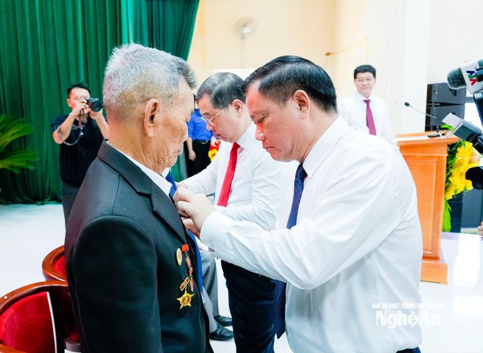 Phó Thủ tướng Thường trực Chính phủ Phạm Gia Túc và Bí thư Tỉnh ủy, Trưởng đoàn ĐBQH tỉnh Nguyễn Khắc Thận đã trao Huy hiệu Đảng cho các đảng viên lão thành. Ảnh: Phạm Bằng