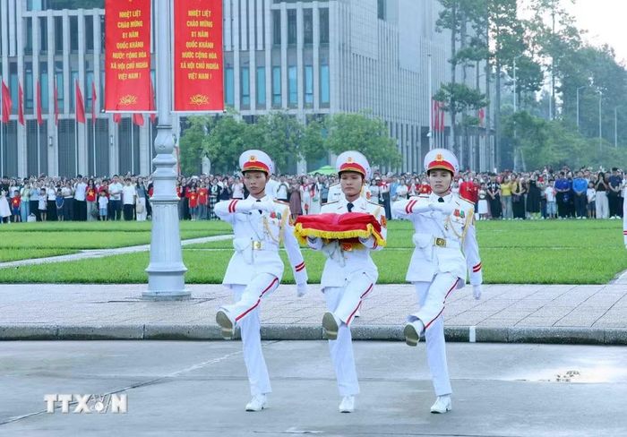 Ba chiến sỹ mang Quốc kỳ tiến về phía cột cờ chuẩn bị thực hiện nghi Lễ Thượng cờ. (Ảnh: Phạm Kiên/TTXVN)