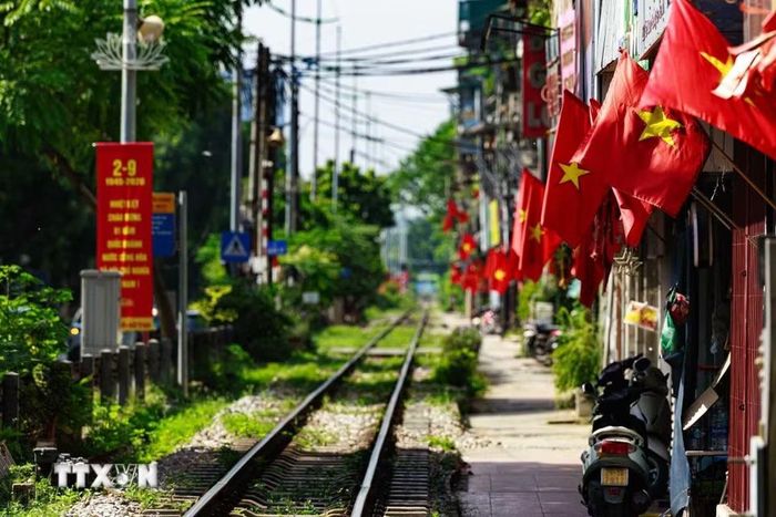 Dọc tuyến đường sắt đi qua khu dân cư, những lá cờ Tổ quốc nối tiếp nhau trước mỗi ngôi nhà, cho thấy không khí Quốc khánh không chỉ hiện diện tại những quảng trường, đại lộ mà còn đi vào từng góc nhỏ của thành phố. (Ảnh: Phạm Tuấn Anh/TTXVN)
