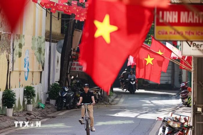 Những lá cờ đỏ sao vàng được người dân treo dọc các ngôi nhà trong khu dân cư, đưa sắc màu của ngày Tết Độc lập len sâu vào những không gian đời thường của Thủ đô. (Ảnh: Phạm Tuấn Anh/TTXVN)