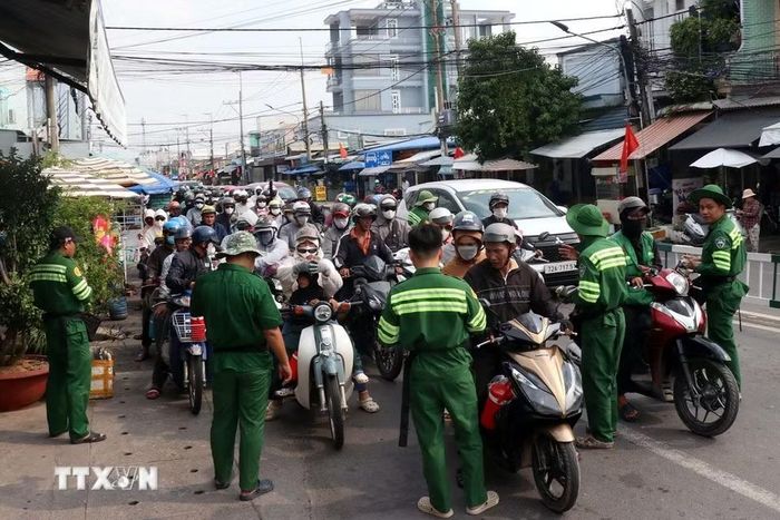 Các nhân viên bến phà Cát Lái được huy động bán vé cho khách ngay trên đường. (Ảnh: Tiến Lực/TTXVN)
