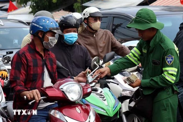 Nhân viên bến phà Cát Lái trực tiếp bán vé cho khách ngay trên đường. (Ảnh: Tiến Lực/TTXVN)