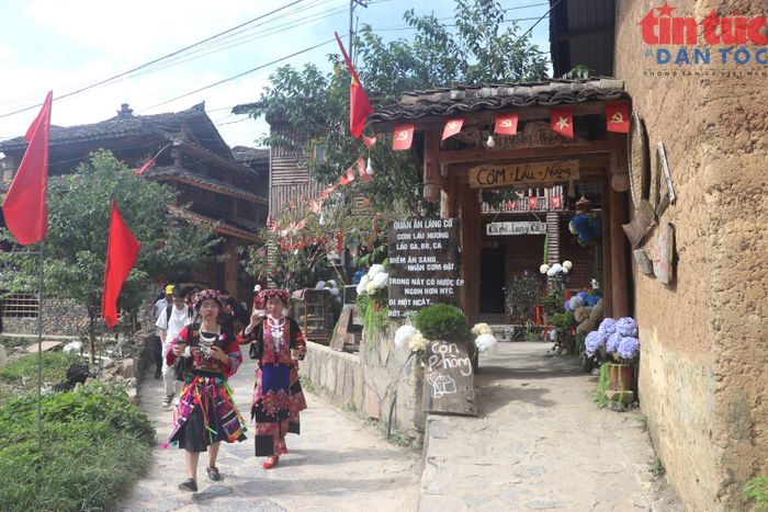 Sắc mầu trang phục truyền thống của phụ nữ Lô Lô nổi bật bên những ngôi nhà trình tường ở làng Lô Lô Chải.