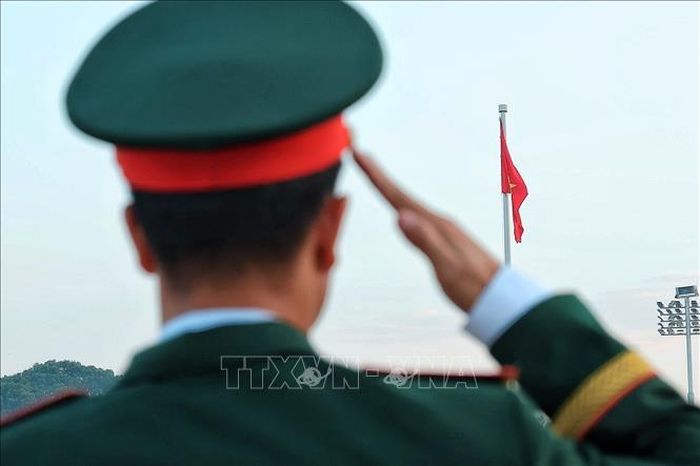 Một quân nhân thực hiện nghi lễ chào Quốc kỳ khi lá cờ đỏ sao vàng được kéo lên trên Quảng trường Ba Đình. Ảnh: Phạm Tuấn Anh/TTXVN