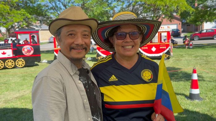 Nghệ nhân Nguyễn Ngọc Tuấn (bên trái) chụp ảnh lưu niệm với vị khách Colombia ghé thăm gian hàng.