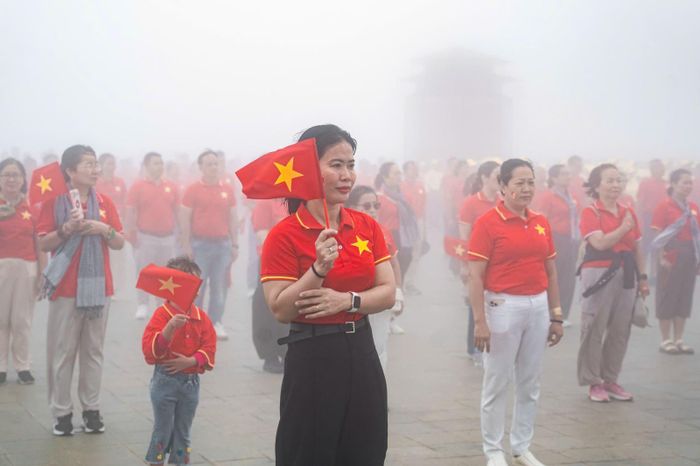Người lớn và trẻ em cùng tham dự lễ chào cờ, thể hiện niềm tự hào và tình yêu quê hương, đất nước