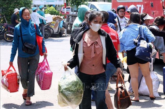 Người dân vội vã trở về nhà với đồ đạc lỉnh kỉnh trên tay tại bến xe Giáp Bát.
