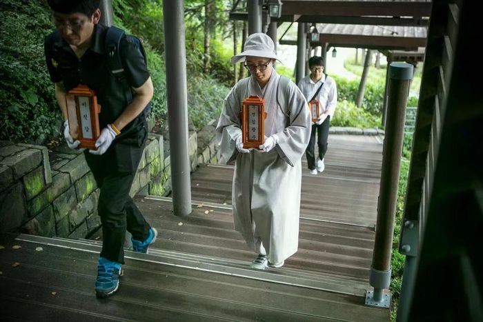 Nhân viên và một nhà sư tình nguyện của một tổ chức phi lợi nhuận mang những tấm bài vị của những người chết trong cô đơn tại một lò hỏa táng ở Goyang, Hàn Quốc. Ảnh: Getty.