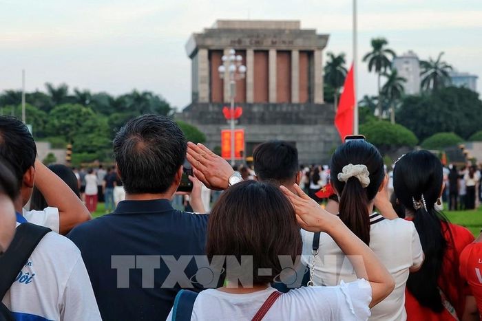 Nhân dân thực hiện nghi thức chào cờ, hướng về Lăng Chủ tịch Hồ Chí Minh trong thời khắc Quốc ca vang lên hùng tráng trên Quảng trường Ba Đình. Ảnh: Phạm Tuấn Anh - TTXVN
