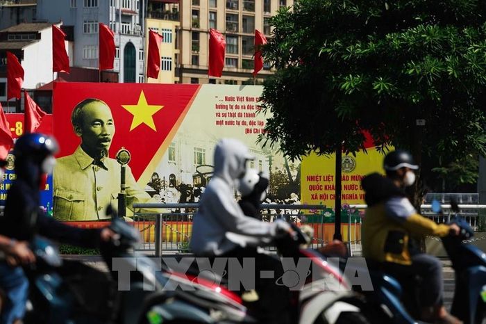 Dòng người qua lại trước pano áp phích cùng những tư liệu về mùa Thu năm 1945 tạo nên sự giao thoa giữa quá khứ và hiện tại, gợi nhắc thời khắc đất nước giành quyền độc lập cách đây 81 năm. Ảnh: Phạm Tuấn Anh - TTXVN